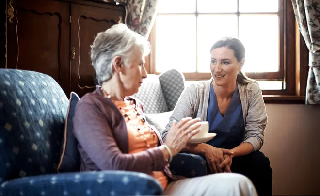 Older woman talking with a younger woman on a sofa